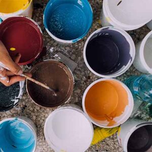 A person painting some different colors of paint.
